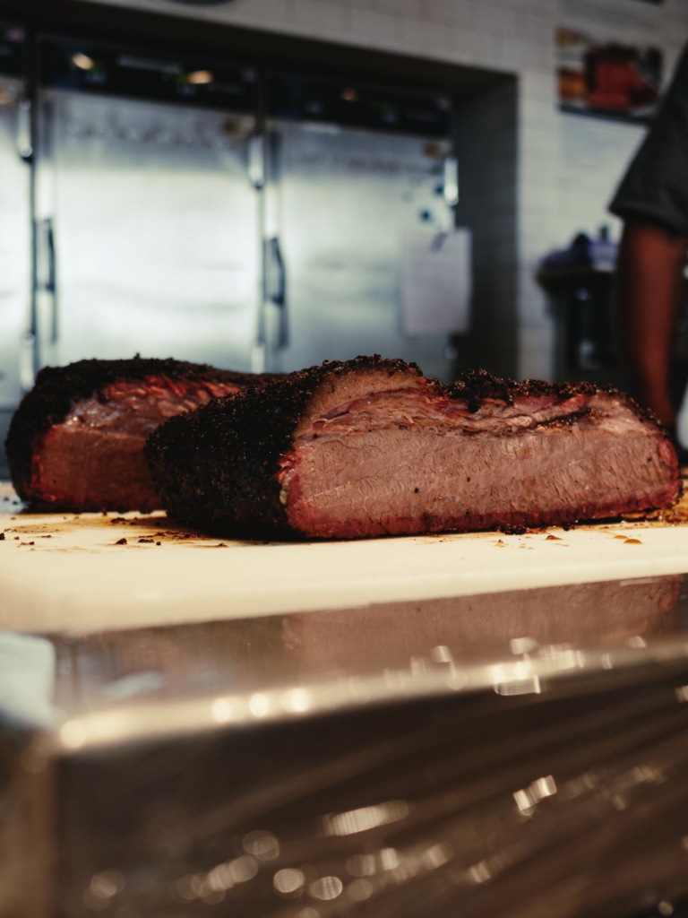 juicy sliced brisket on cutting board in kitchen
