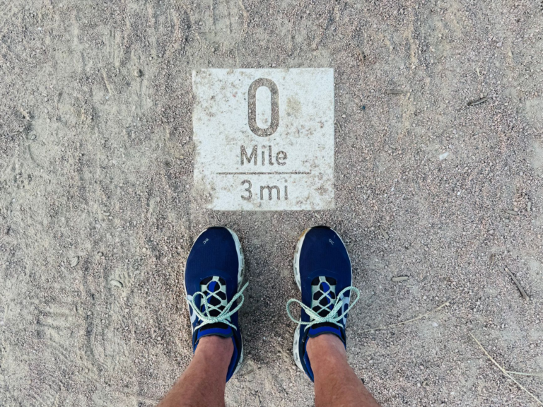 runner s perspective of mile marker on dusty path