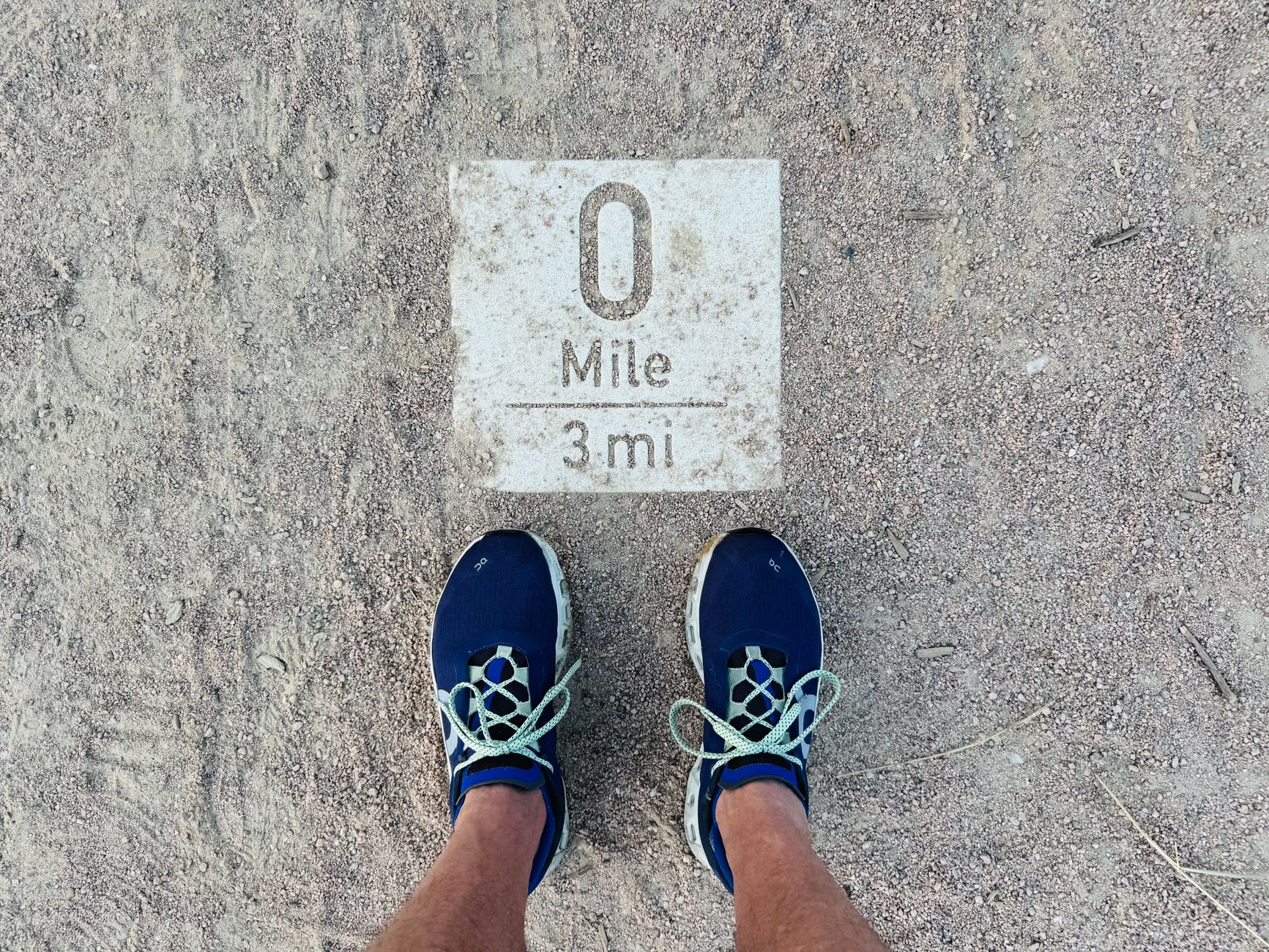 runner s perspective of mile marker on dusty path